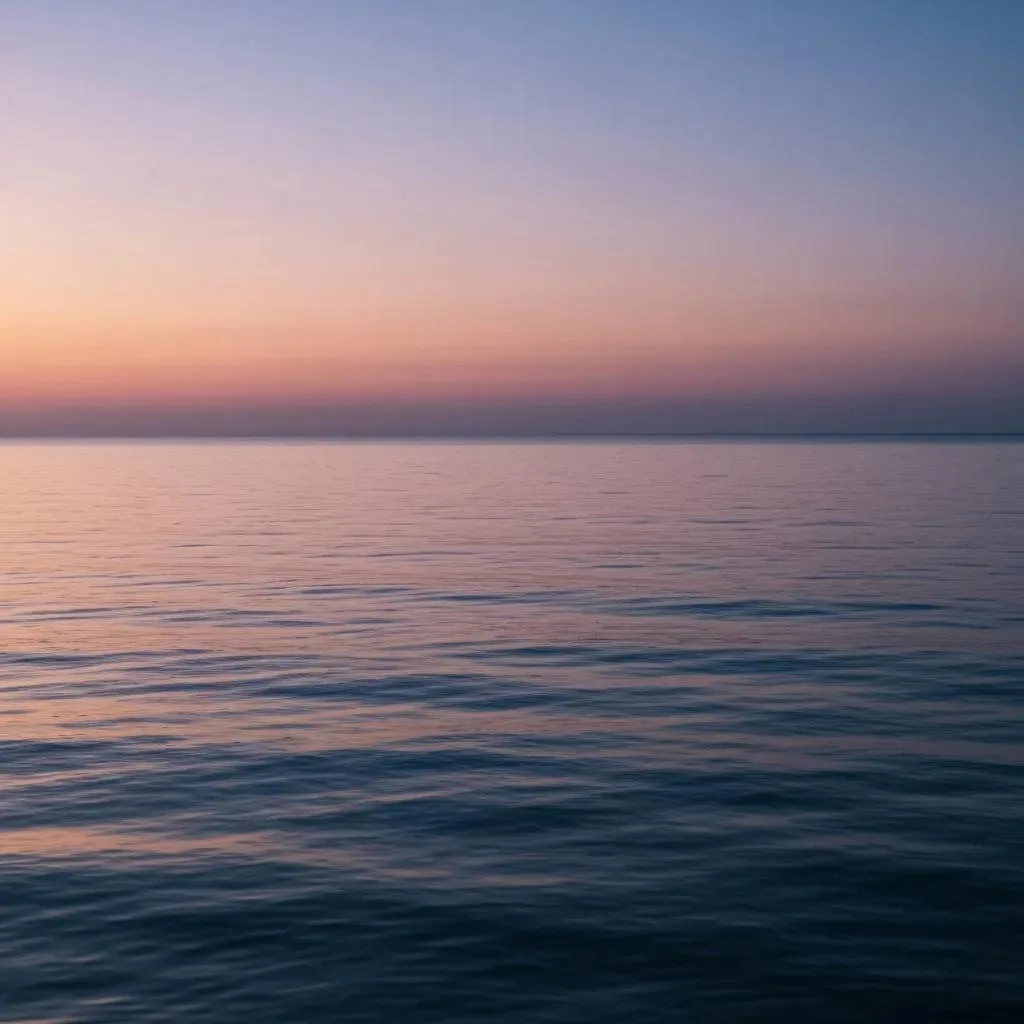 Serene ocean view at sunset, featuring calm waters reflecting pastel colors of the sky, symbolizing tranquility and recovery in addiction treatment context.